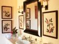 Španělský styl této koupelny navrhl Michael S. Smith, zarámované textilní motivy kombinuje se svícny (Robert Kime) a zrcadlem od HomArt (foto: Tim Beddow)